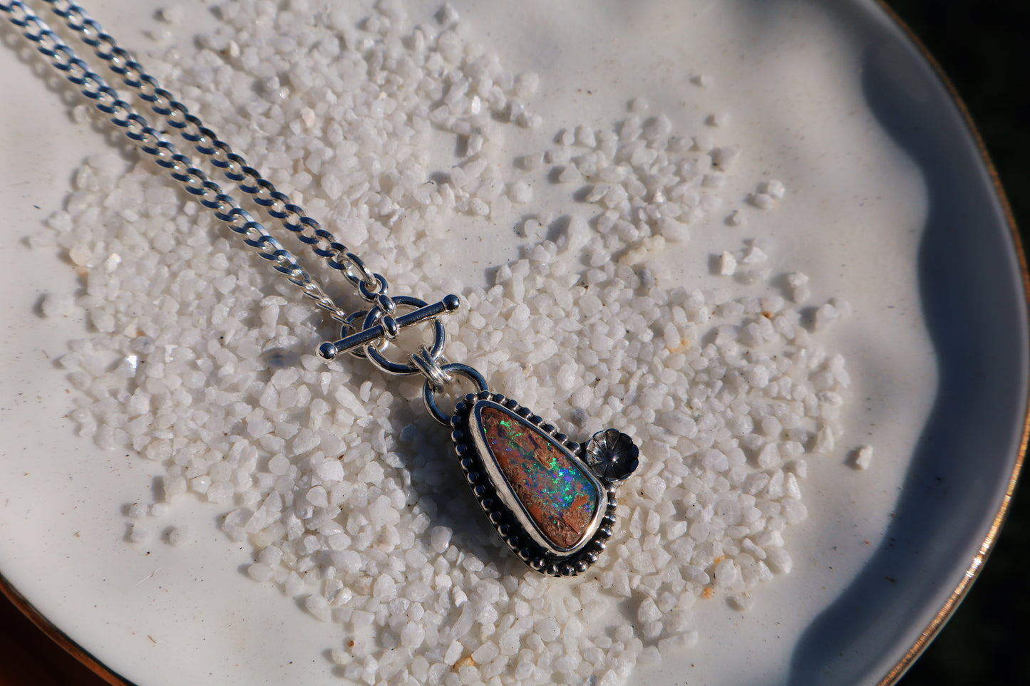 Sparkly green boulder opal toggle pendant with beaded and floral accents. 18in flat curb chain. Sterling silver.