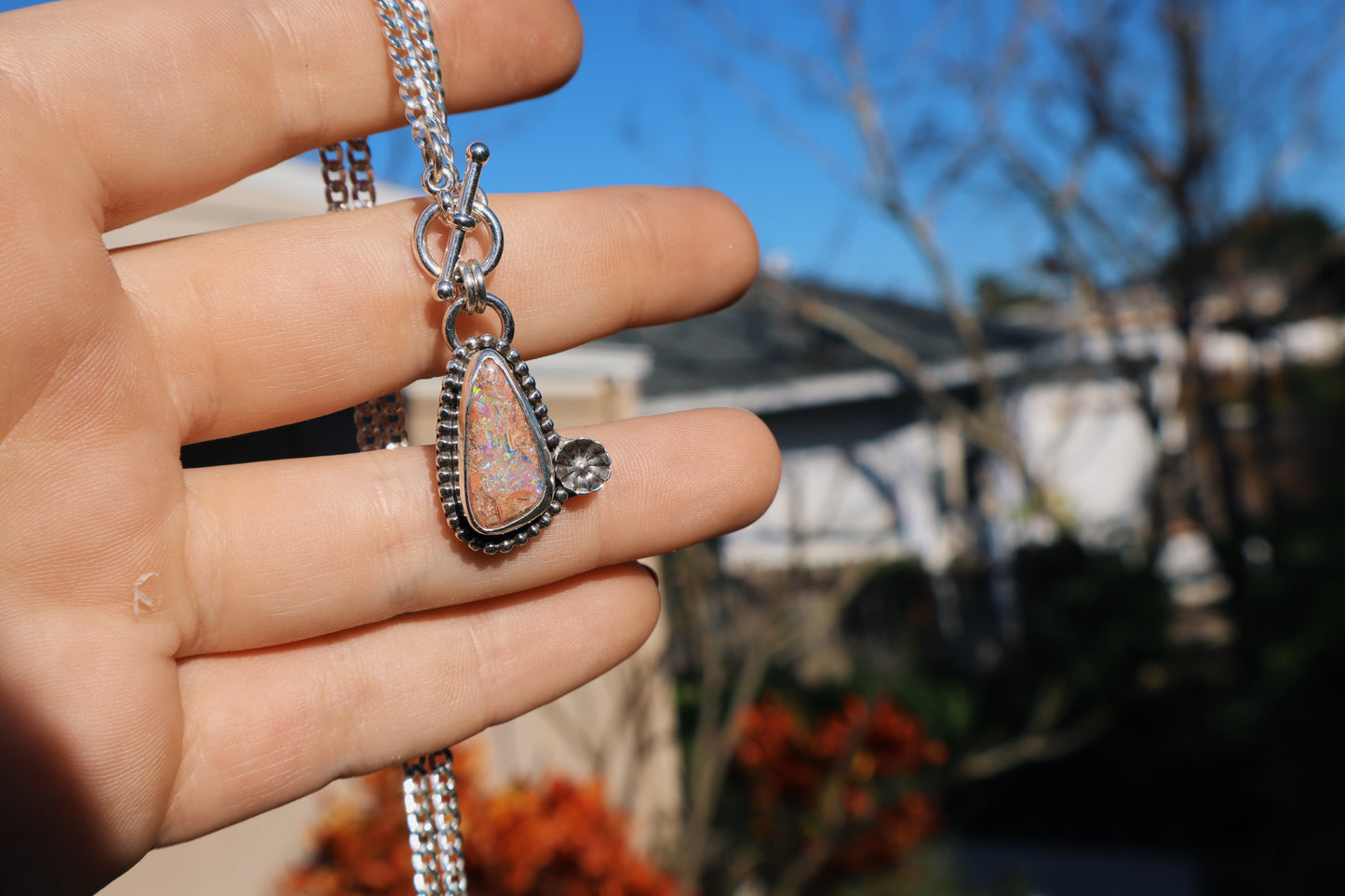 Sparkly green boulder opal toggle pendant with beaded and floral accents. 18in flat curb chain. Sterling silver.